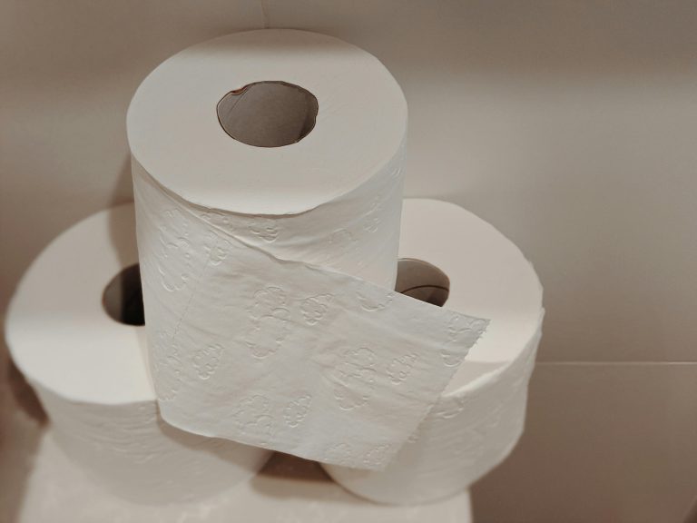 A neatly stacked pile of white toilet paper rolls, ideal for bathroom essentials and hygiene supplies.